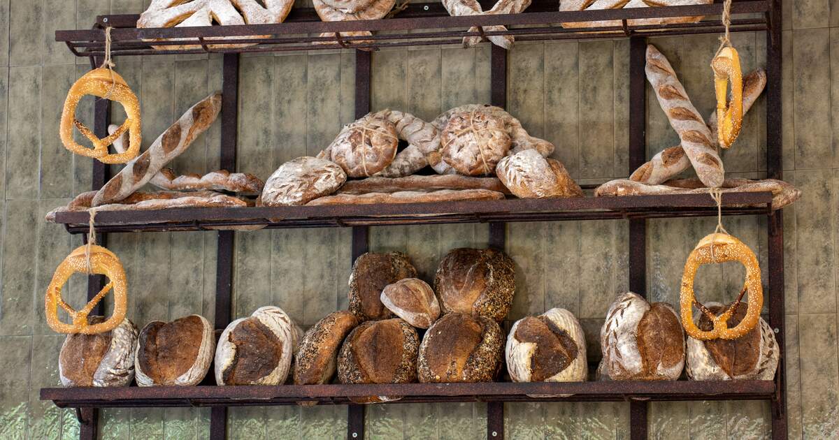 An assortment of freshly baked artisan bread loaves arranged on bakery shelves