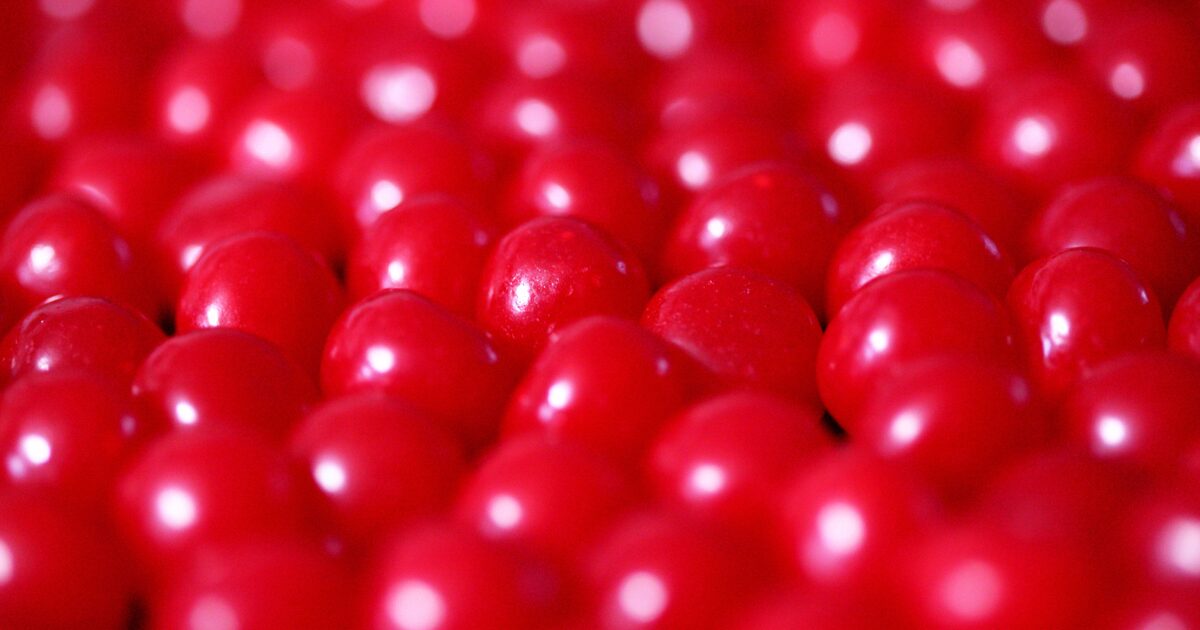 A close-up of bright red round candies filling the frame