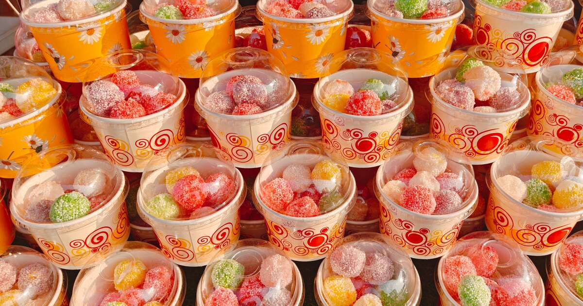 Colorful sugar-coated jelly sweets in paper cups on a market stall