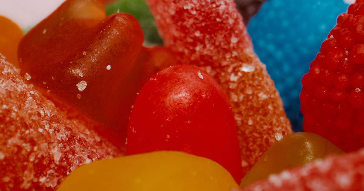 A macro view of brightly colored red and orange sugar-coated candies