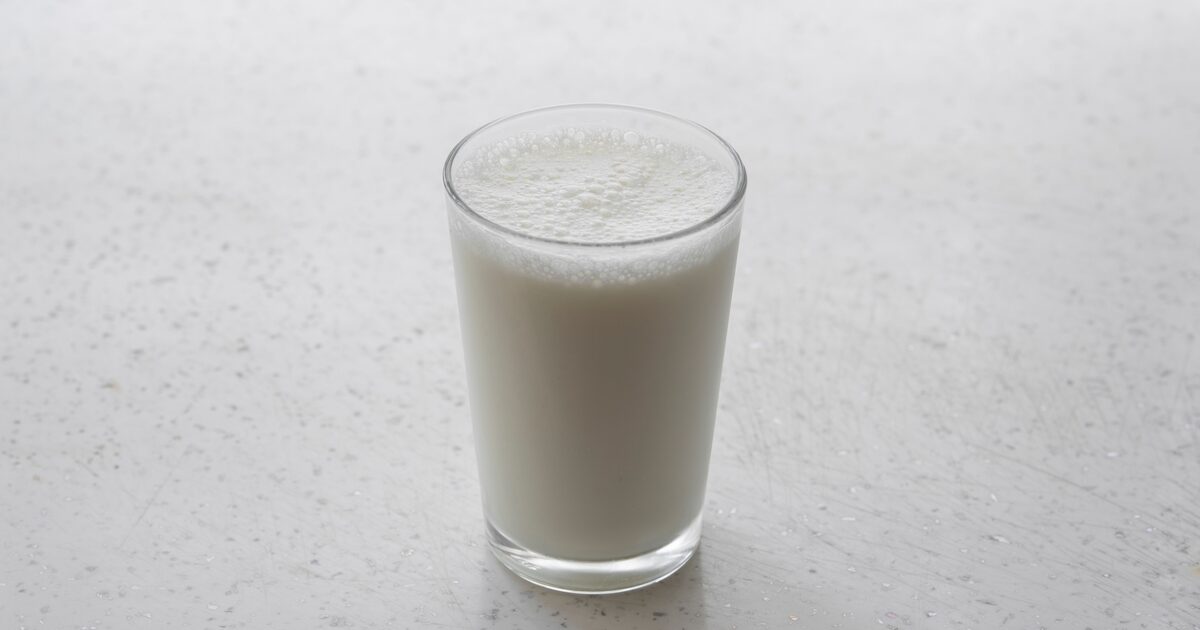 A frothy glass of milk on a light textured surface
